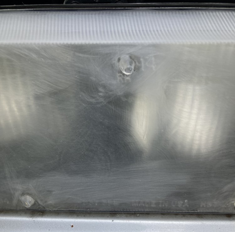 A closeup of my passenger headlight after the first round of sanding; the yellowing across the top of the light is gone, and it is now as cloudy as the rest of the housing