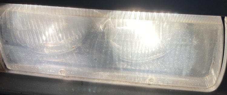 A shot of my passenger headlight from above before restoration with low and high beams engaged; there is a noticeable amount of light reflected by the housing instead of transmitted through it